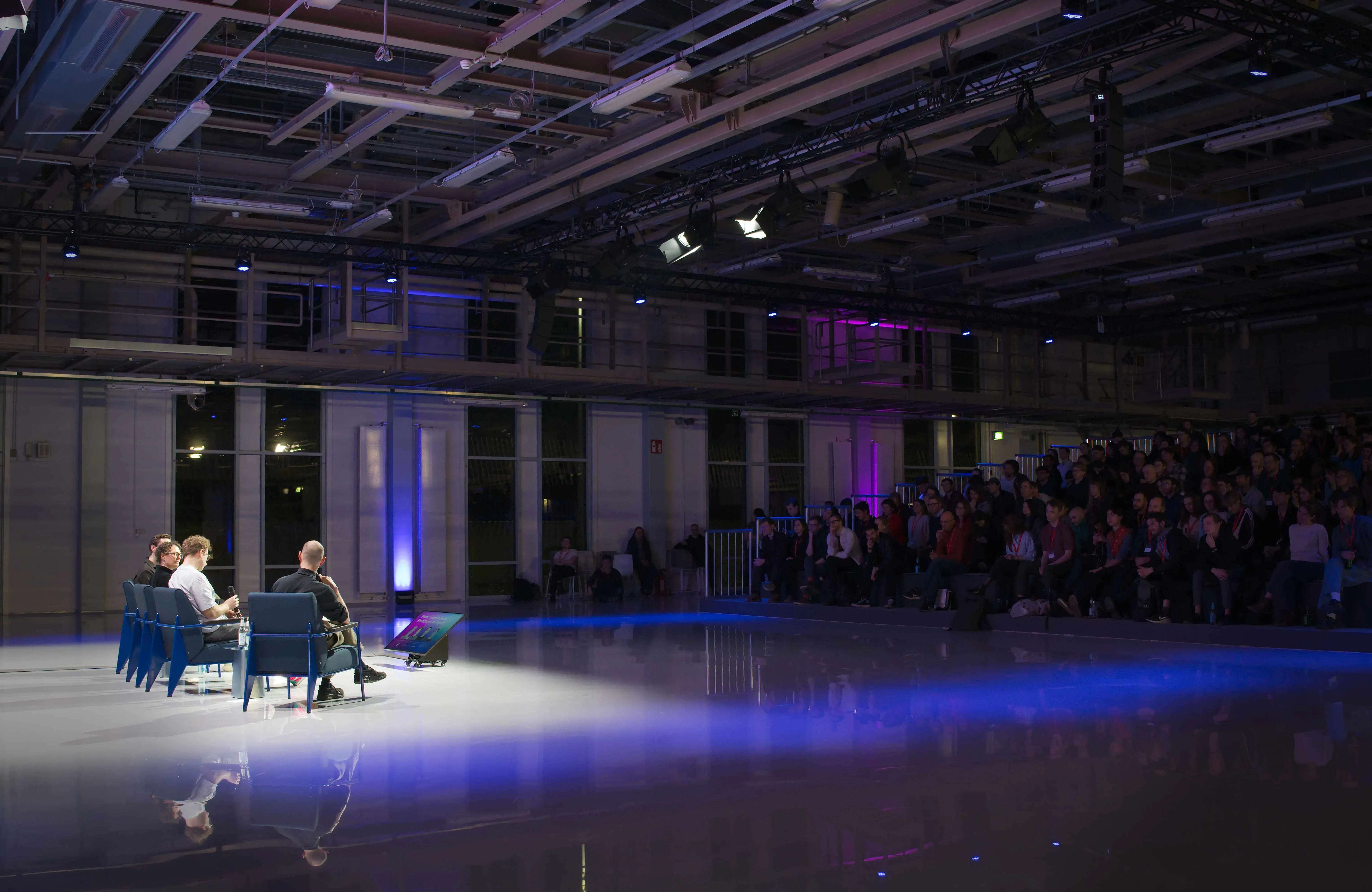 Abend-Gala im NLND mit Gästen an Tischen und großflächiger blauer Illumination